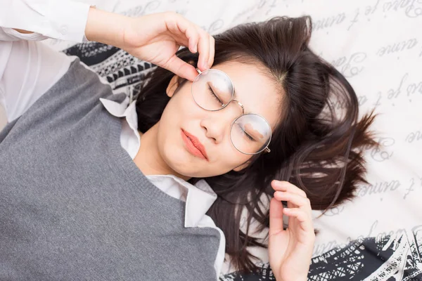 Gafas de mujer relajarse acostado en la cama —  Fotos de Stock