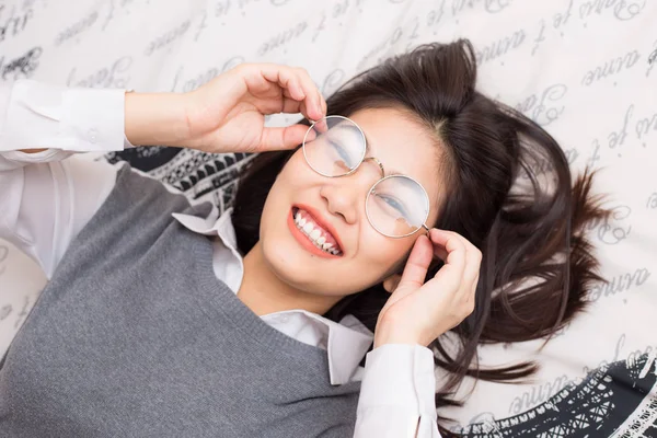 Glasögon kvinnor slappna liggande på sängen — Stockfoto