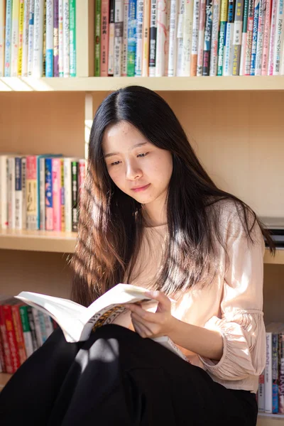 Красивая азиатская девушка красная книга сидит в комнате — стоковое фото