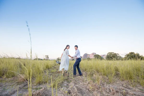Casal de amor correndo juntos no campo verde — Fotografia de Stock
