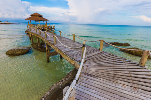 Sea beach with wooden bridge into wood hut