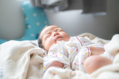 Battaniyenin üstünde uyuyan sevimli bebek.