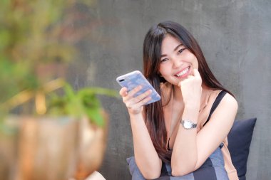 Güzel Asya Smiling kadınlar kullanarak Smartphone içinde kahve dükkanı