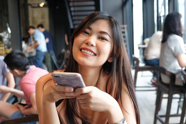 Mooie Aziatische lachende vrouwen met behulp van smartphone in Coffee Shop — Stockfoto