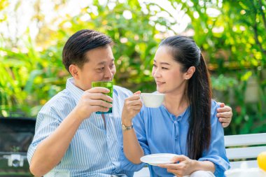 Mutlu olgun çift yeşil bahçede birlikte konuşurken