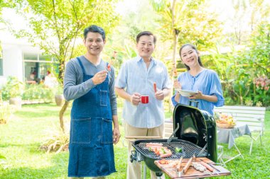 Barbekü gıda ile ev bahçesinde insan piknik partisi Grubu