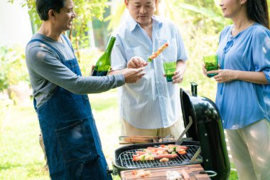 Barbekü gıda ile ev bahçesinde insan piknik partisi Grubu