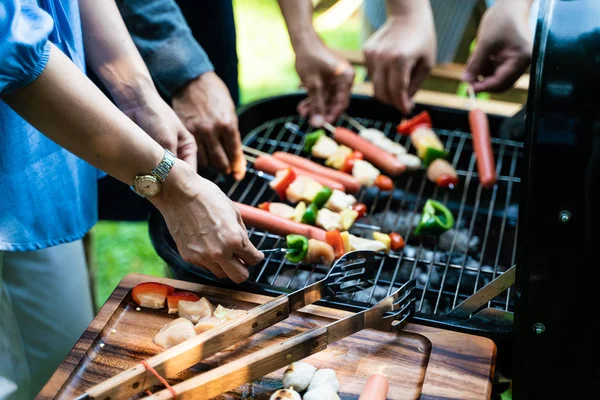 Grupa ludzi piknik party w ogrodzie domowym ze sprzętem do grillowania — Zdjęcie stockowe