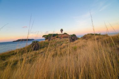 Renkli gökyüzü bulutu ile deniz kıyı şeridi günbatımı ada