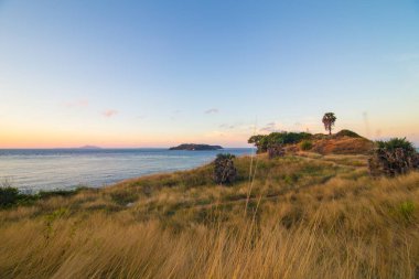 Renkli gökyüzü bulutu ile deniz kıyı şeridi günbatımı ada