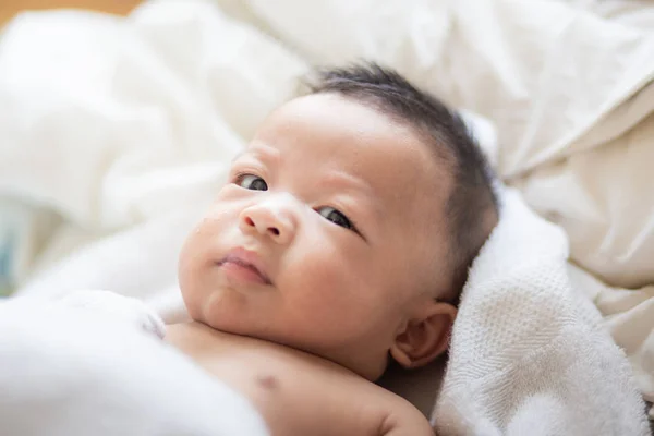 Divertido bebé niño acostado en la cama después de despertar — Foto de Stock