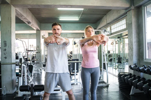Sport man trainning women work out in fitness gym sport club