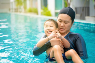 Çocuk çocuk yüzme havuzunda anne ile yüzme öğrenmek