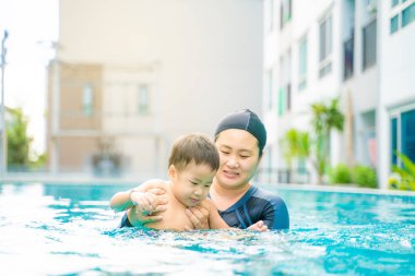 Çocuk çocuk yüzme havuzunda anne ile yüzme öğrenmek