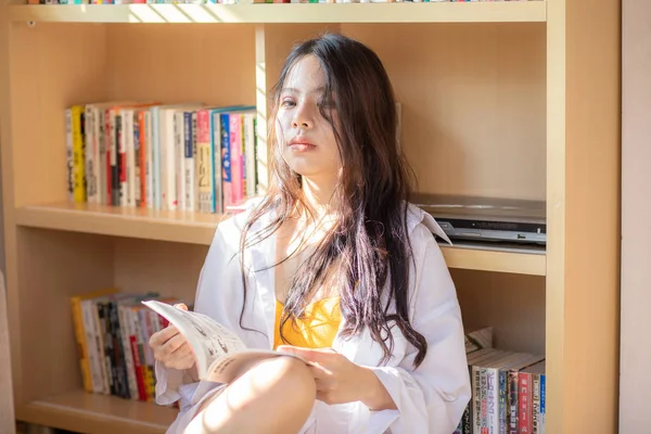 Portrait de jeunes belles femmes asiatiques avec livre sur étagère backg — Photo