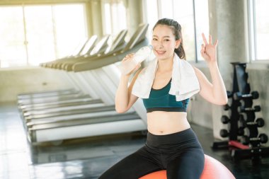 Şişede su içen sportif asyalı kadınlar