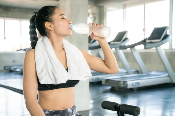 Sporty asian women drinking water in bottle