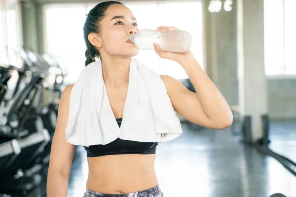 Sporty asian women drinking water in bottle
