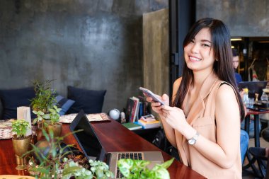 Kafede akıllı telefon kullanan mutlu genç iş kadınları