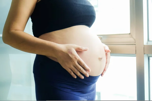 Jóvenes hermosas mujeres embarazadas de pie en la habitación acogedora — Foto de Stock