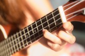 Ženy hrající ukulele s paprsky slunce