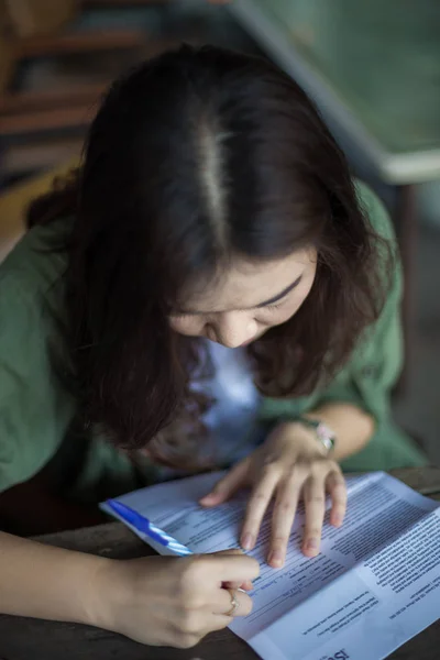Азіатські жінки, що пишуть на папері в таблиці — стокове фото