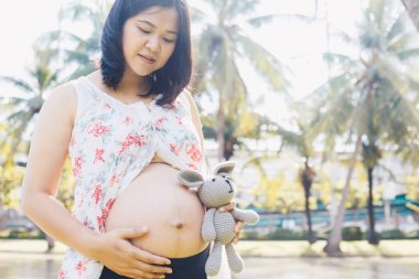 Asyalı hamile kadınlar şehir kamu yeşil parkta poz
