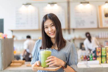 Güzel kadınlar kafe parkta buz içecek fincan tutun