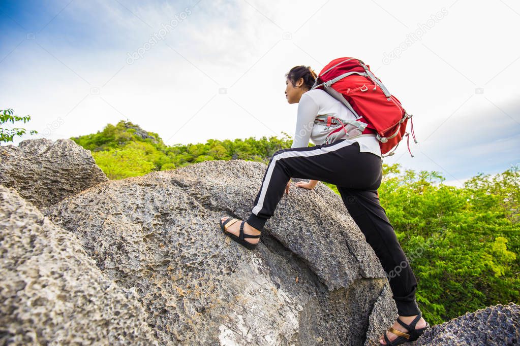 Happy hiking women stand on top of mountain with backpack