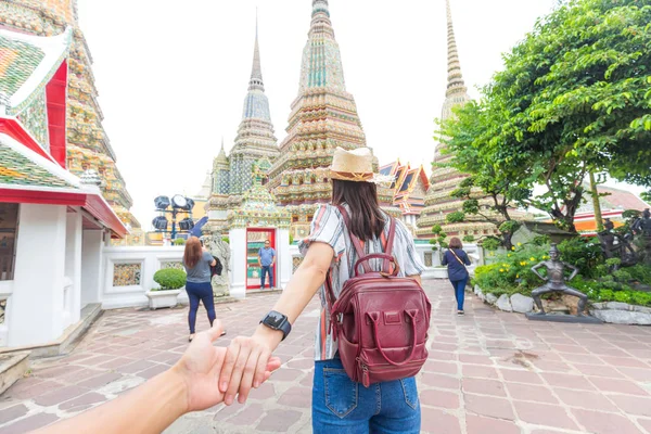 Vackra turist kvinnor med ryggsäck ledande man hand resa i — Stockfoto