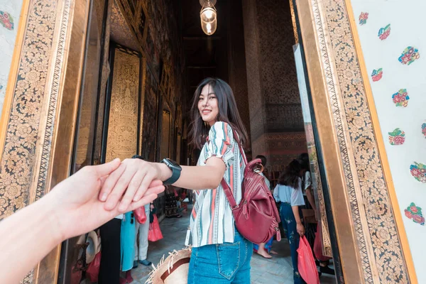 Mulheres turísticas bonitas com mochila levando homem mão viajar em — Fotografia de Stock