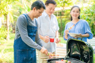 Barbekü ızgara ve içecek ile orta yaş Parti grubu