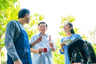 Barbekü ızgara ve içecek ile orta yaş Parti grubu