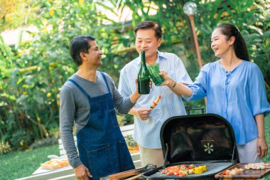 Barbekü ızgara ve içecek ile orta yaş Parti grubu