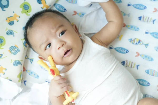 Adorável bebê menino brincando de brinquedo na cama — Fotografia de Stock