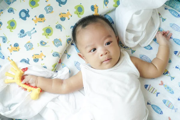 Sevimli bebek bebek çocuk yatakta oyuncak oynarken — Stok fotoğraf