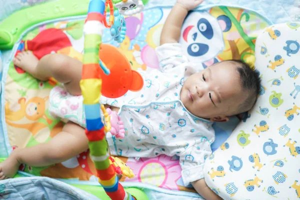 Очаровательный малыш, играющий в игрушки на кровати. — стоковое фото