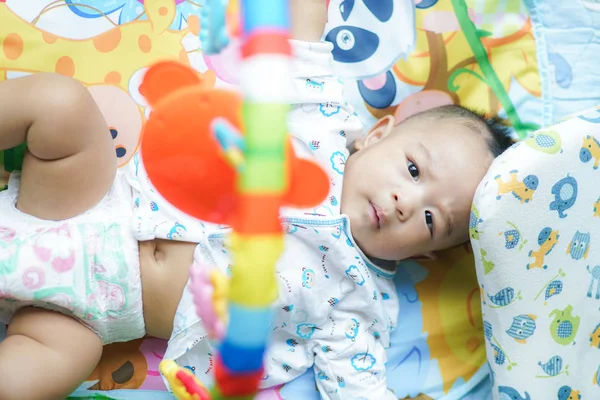 Adorable niño pequeño jugando juguete en la cama — Foto de Stock