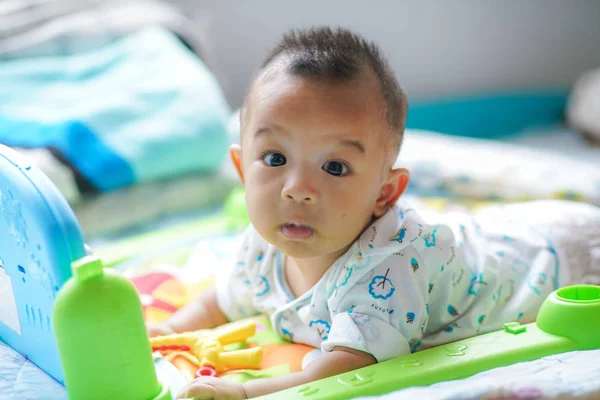 Adorable niño pequeño jugando juguete en la cama — Foto de Stock