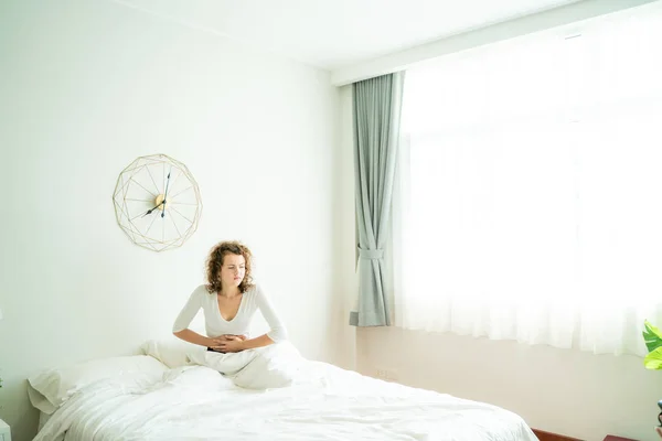 Kaukasische Frauen mit Bauchschmerzen wachen im Bett auf — Stockfoto