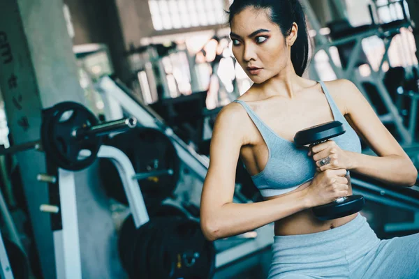 Wellbeing smart asian sport women lifting dumbbell in gym — Stock Photo, Image