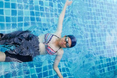 Hamile kadınlar havuzda yüzüyor.