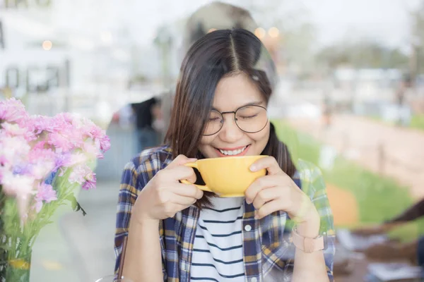 Piękne azjatyckie okulary kobiety pijąc latte kawa w kawiarnia — Zdjęcie stockowe