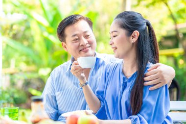 Asyalı yaşlı çift yeşil parkta kahve içme