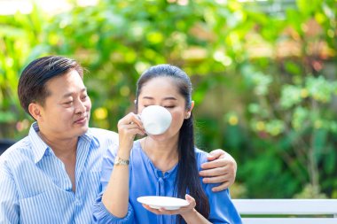 Asyalı yaşlı çift yeşil parkta kahve içme