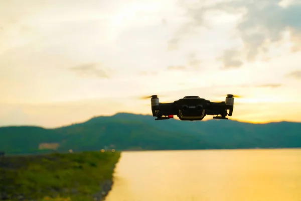 Drone silueta volando sobre el atardecer del lago —  Fotos de Stock