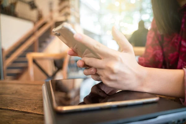 Kvinnor hand använda smartphone och bärbar dator med kaffekopp — Stockfoto