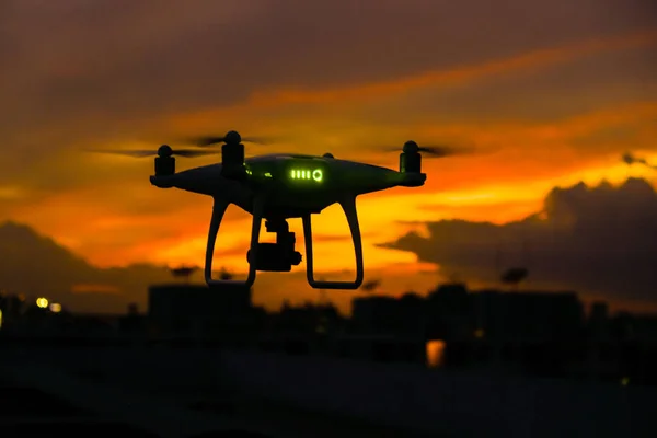 Drone flying over silhouette city sunset sky with cloud