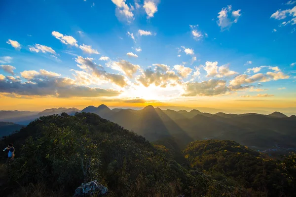 Colorido cielo majestuoso atardecer con nubes en la cima de la montaña — Foto de Stock