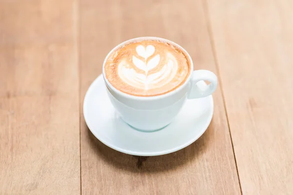 Latte art textúra kávé fehér csésze fa asztal — Stock Fotó